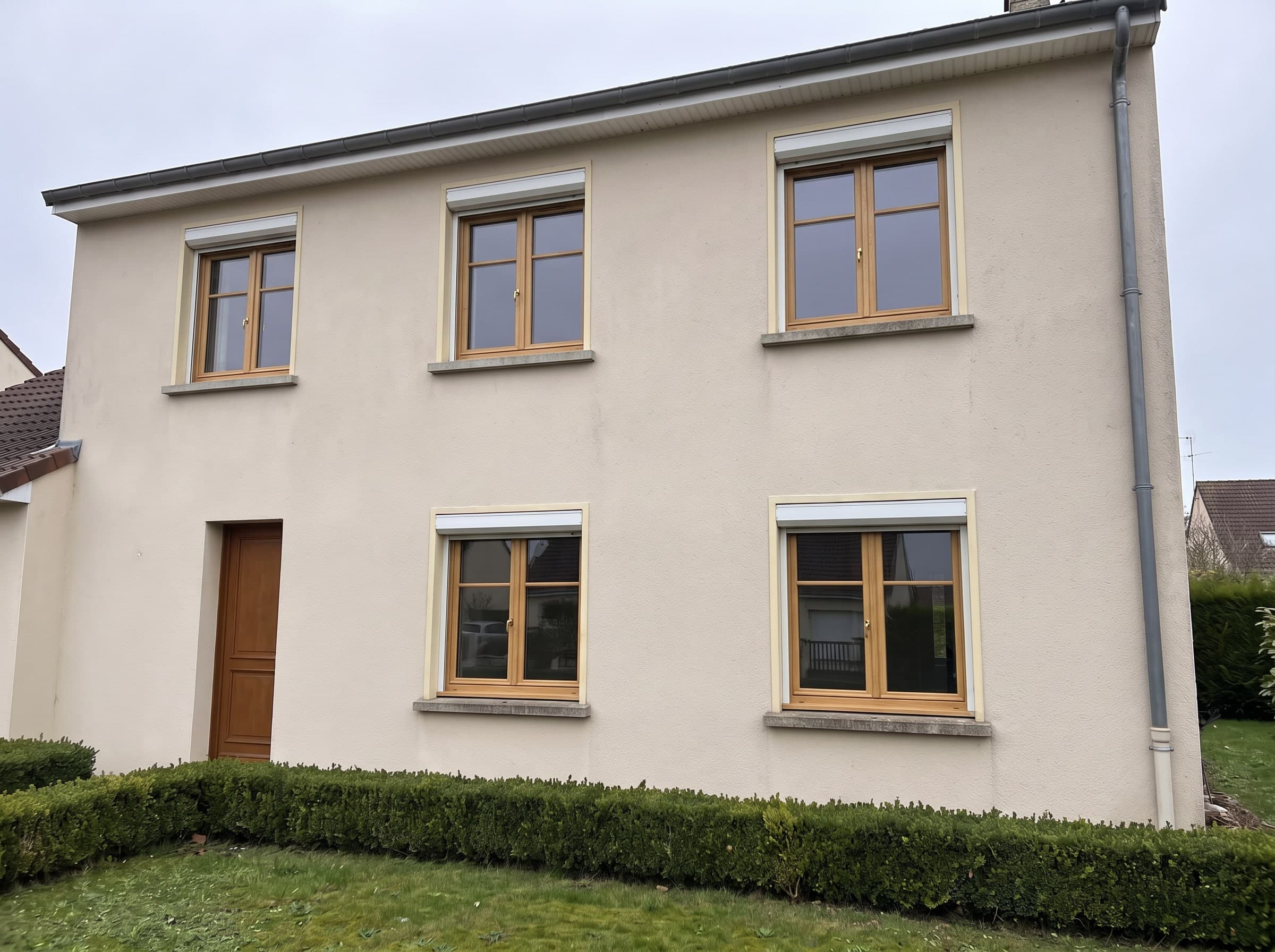 Dieselbe Fassade mit Fenstern aus heller Eiche mit zwei Flügeln und einer waagerechten Sprosse