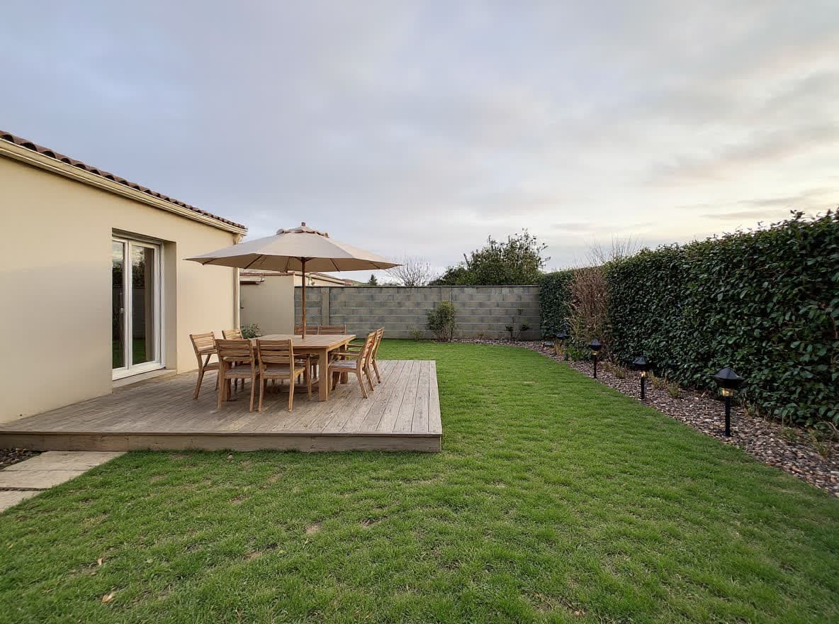 Familiengarten: große Terrasse aus hellem Holz mit Essbereich