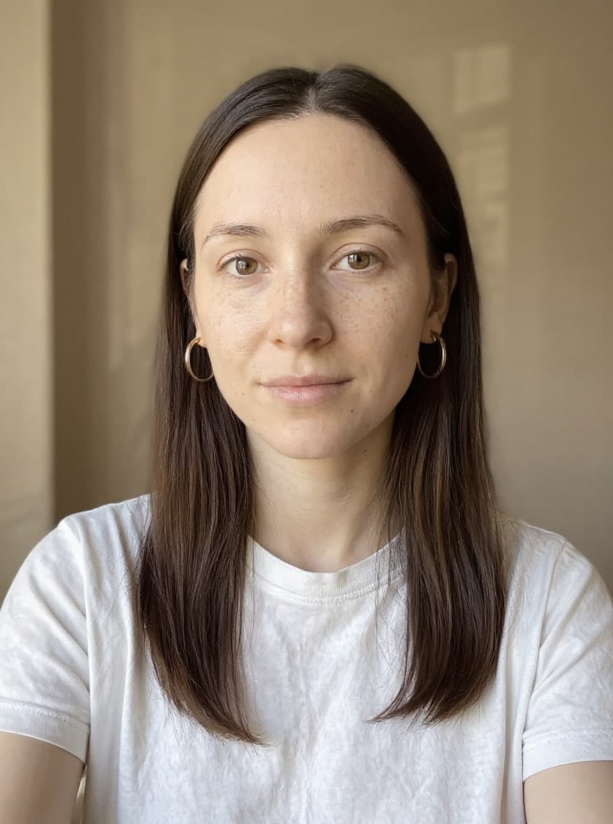 The same woman, hair tucked behind her ears, wearing polished gold hoops about three centimetres wide