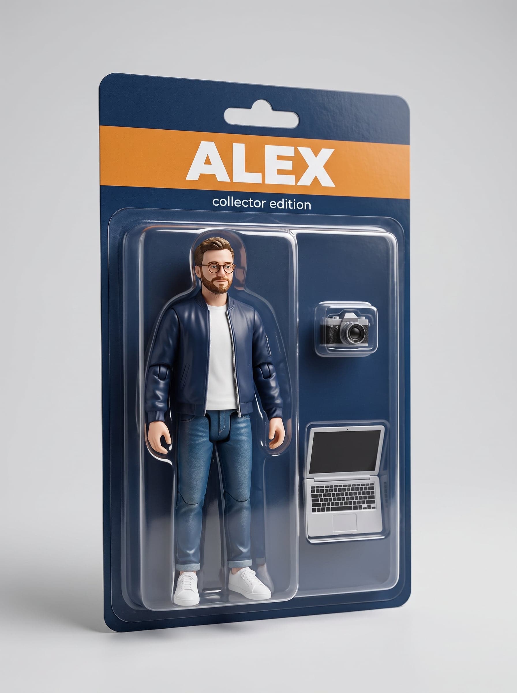 Action figure pria berkacamata dengan jaket biru, dalam kemasan blister, dilengkapi aksesori kamera dan laptop.